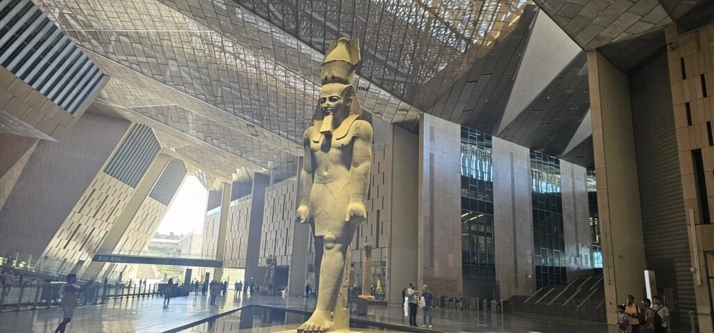 Visitantes explorando o Grande Museu do Egito (GEM) em Cairo, acompanhados de guia em português. Contato WhatsApp: +20 120 412 8282 – Guia Viagem Egito