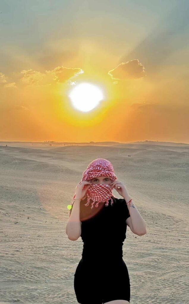 Tour do pôr do sol no Egito com vista panorâmica sobre o deserto e as pirâmides, céu alaranjado refletindo nas dunas e viajantes apreciando a paisagem. Para reservas: +201204128282