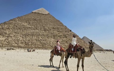 Turistas LGBTQ+ apreciando a vista das Pirâmides de Gizé ao pôr do sol